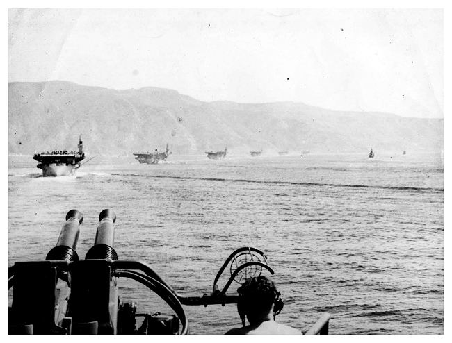 Seven Royal Navy escort carriers operated in the Mediterranean and the Aegean: H.M. Ships Attacker, Emperor, Huller, Khedive, Pursuer, Searcher, and Stalker, all are in line astern behind Emperor in this shot. Photo: Jack Price via Carl Berrington