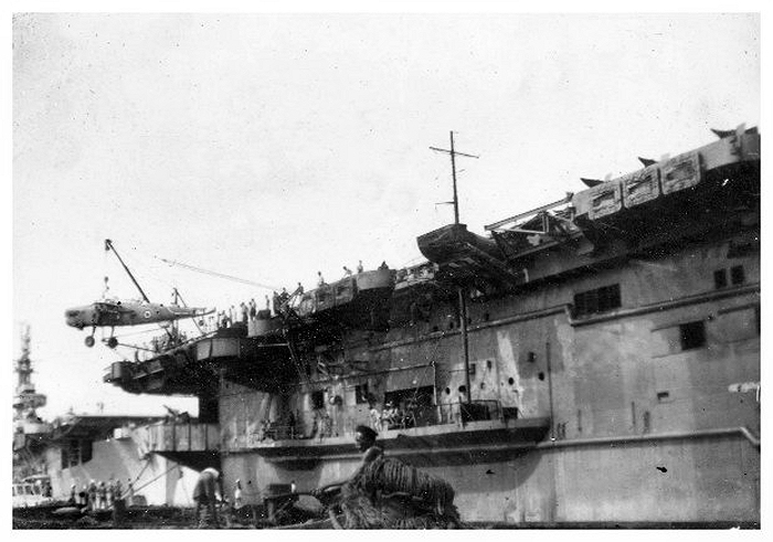 HMS Queen loading Barracuda fuselages in Colombo Harbour January 1946; HMS Patroller is moored behind her. The aircraft are for dumping at sea.