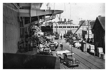 HMS Slinger alongside in Hong Kong unloading food and medical supplies for the colony.  Photo: Courtesy of E.C. McCarthy