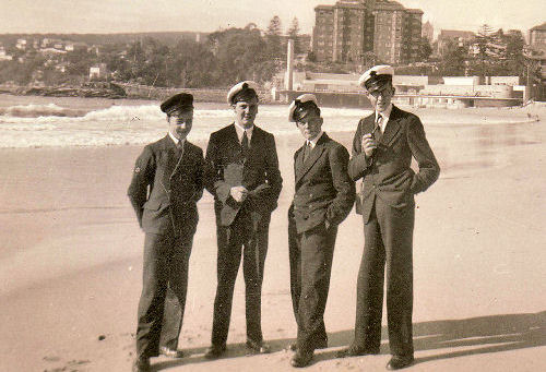 Droup of four men in uniform on a beach in Sydney