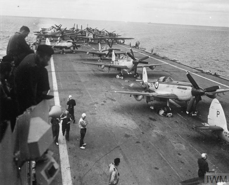 HMS TRIUMPH under way with Seafires and Fireflies parked on her flight deck.