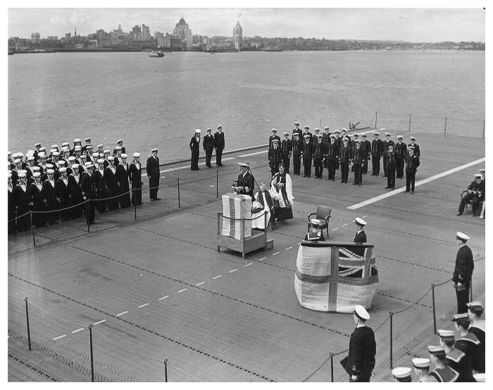 Saturday July 1st. commissioning ceremony and dedication service on the flight deck: Captain Baker reading the Ships’ Commissioning Warrant. [Photo: Maureen Ross]